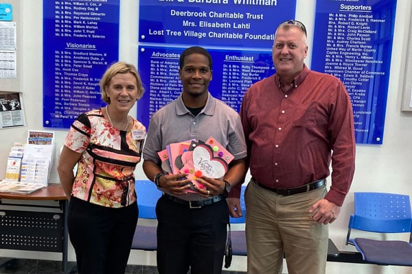 Jill Ball, president, and Brian Langworthy, Business Development executive for VIP, right, with Anthony Davis with Boys & Girls Club, Indiantown. Students donated handmade cards.